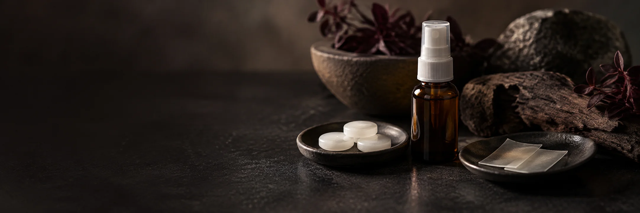 An unmarked small spray bottle, plain white lozenges and thin translucent strips illustrating peptides nasal sublingual product-format context.