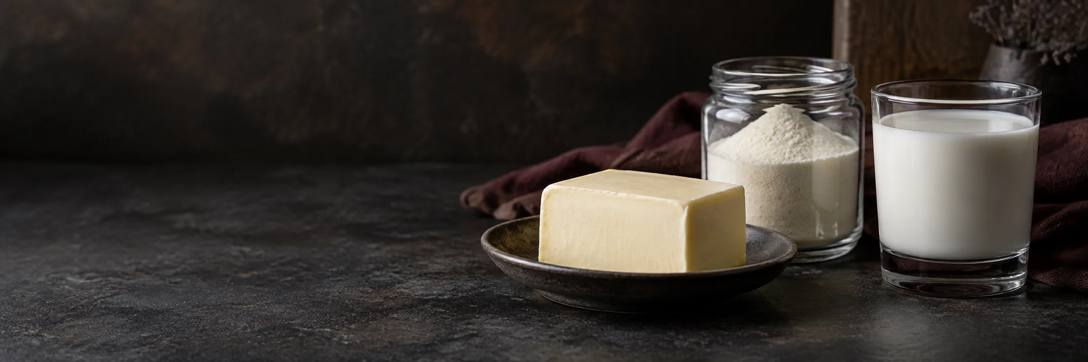 A butter block, an unmarked jar of fine pale powder and a glass of milk illustrating Bandara 2020 protein-powder supplement study research context.