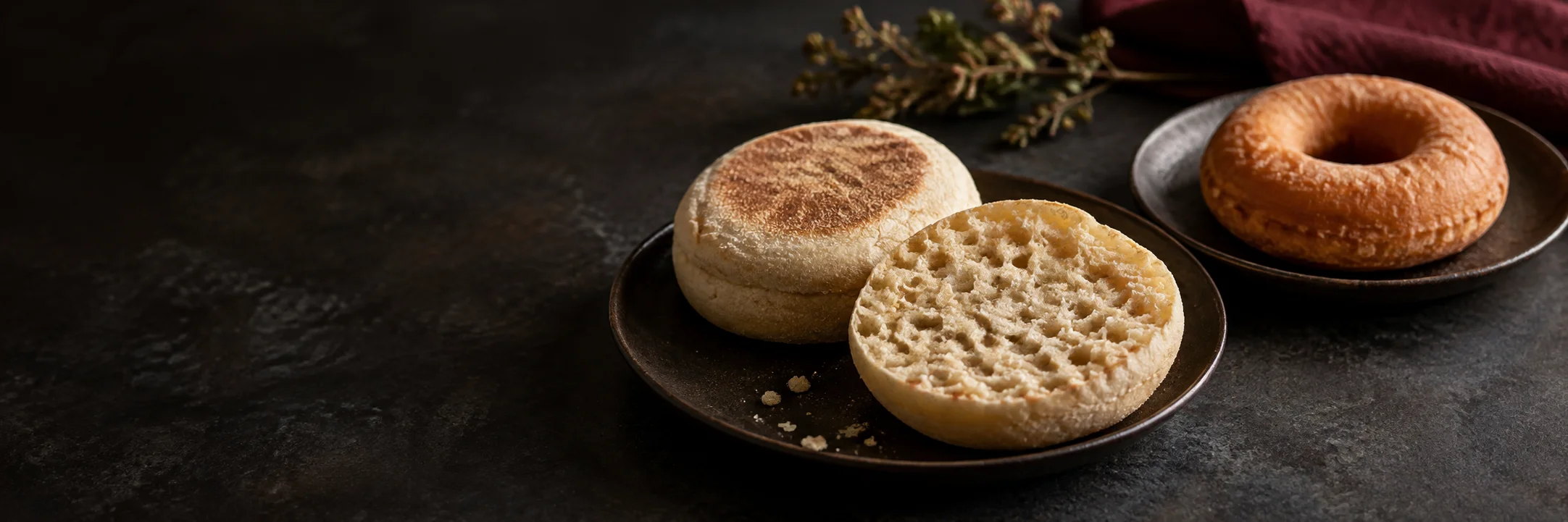 Whole and cut English muffins and a separate plain ring doughnut illustrating english muffin ingredient context.
