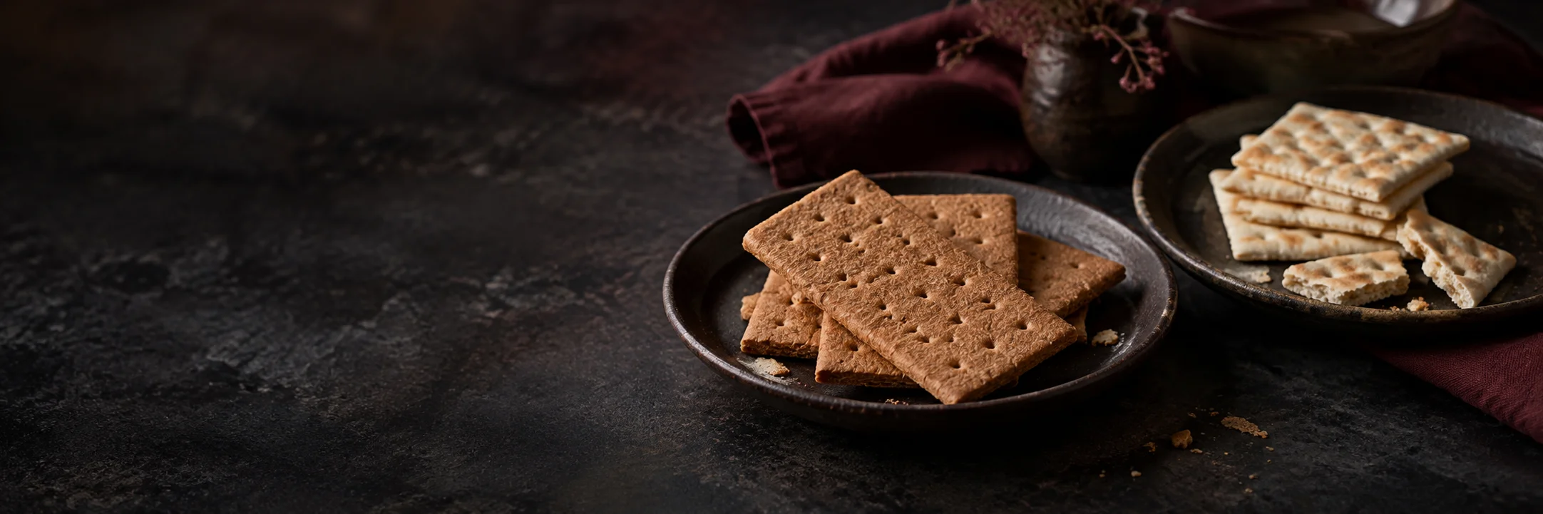 Rectangular brown graham crackers and a separate stack of pale square crackers illustrating graham crackers ingredient context.