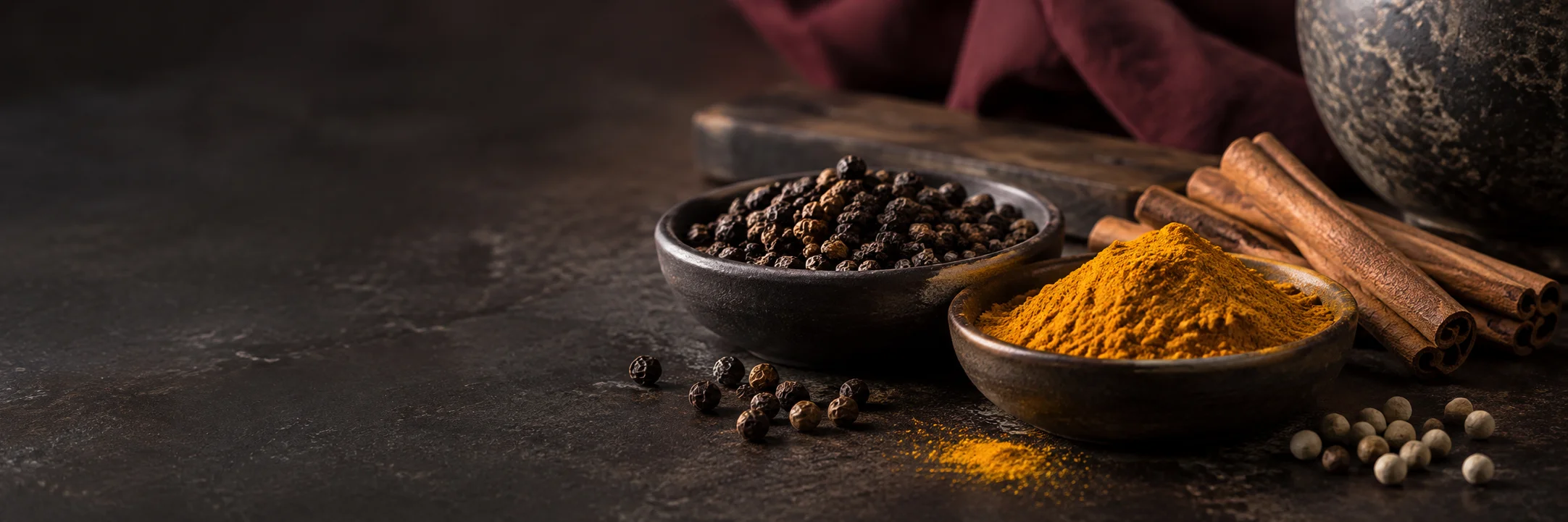 Black and pale peppercorns, turmeric powder and cinnamon sticks illustrating adams2017 nigerian processed spices metals research context.